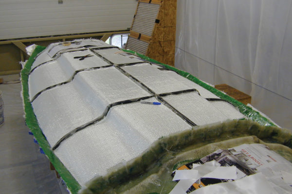 Fitting heavy fabric to the mold. The black ribs (old garden hose hot-melt glued on) stiffen the assembly.