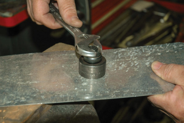 A small hole is drilled in the aluminum for the oil lines. Then a hole cutter is used to make the larger hole. This cutter helps to keep the aluminum from warping and leaves a smooth-edged hole.