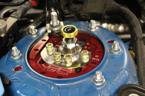 Here’s a typical strut setup with a camber plate to allow for greater alignment adjustability. Note the yellow damper adjustment knob (center) for rebound/extension resistance.