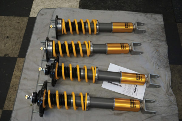 This coilover setup from Ohlins (shown here in component form and final assembly) will cost several thousand dollars, but it’s a top-quality motorsports product. The Ohlins coilovers offer damping adjustment and spring preload. Total height adjustment comes from an extra threaded part at the bottom of the strut body. This part simply extends or retracts the strut to allow the tuner to set ride height and corner weights.