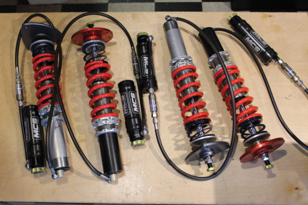 High-end units like these from Motion Control Suspension include remote gas reservoirs. The reservoirs offer convenient recharging as well as an additional adjustment knob. Note the other adjustment knob on the top of the strut rod.