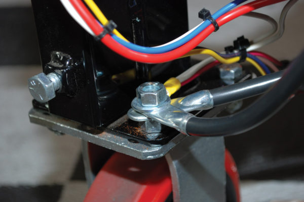 The negative battery cable ground and frame-to-engine ground were attached to a bolt that secures one of the casters. It’s important to ground the engine to avoid damage to the other electrical circuits. We also used this location to ground the dash panel, electric fan and auxiliary circuit.