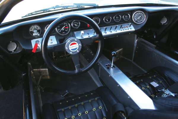 Classic Instruments gauges are mounted across the fiberglass dash along with the appropriate switch gear, all labeled for quick reference.
