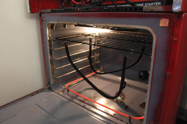 Once you’re satisfied that the parts are fully coated, carefully transfer the rack and hanging parts (wind wing frames shown here) to the oven that has been preheated to 450 degrees. Be careful not to bump the parts against anything to disturb the dry powder. Keep an eye on the parts in the oven every five minutes or so until it’s obvious that the powder has flowed out evenly, then reduce the temperature of the oven to 400 degrees and set your timer for 20 minutes.