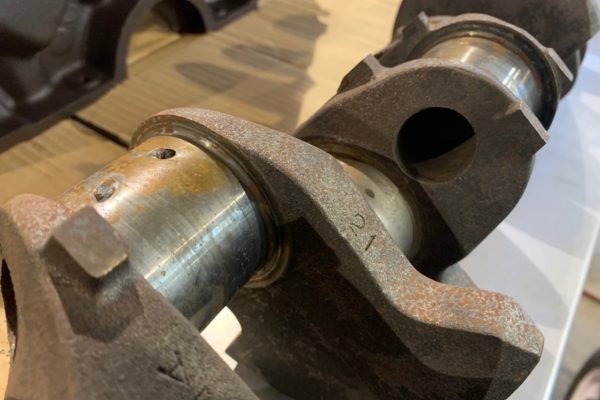 Our original crankshaft had some decent wear on the journals, definitely enough to catch a fingernail on. So it was either polish this cast iron unit or upgrade to the cast steel crank in the Summit stroker kit.