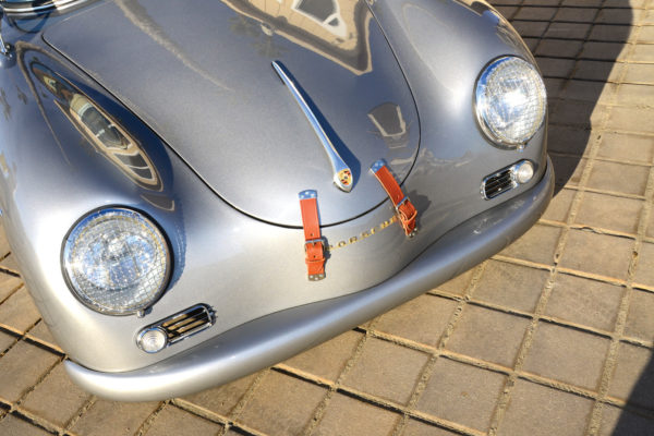 Leather straps for the hood impart a period-correct treatment to a classic Speedster replica with a modern mill.