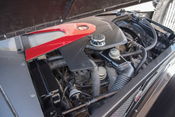 While a Chevy V8 can fit under the hood, this particular car cruises with a milder Dodge V6 with a custom engine cover.